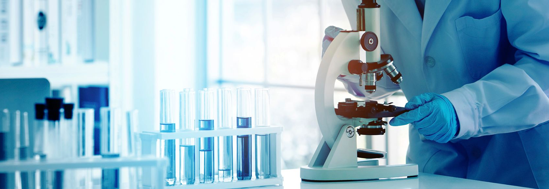Samples in tubes and a lab technician looking at samples through a microscope